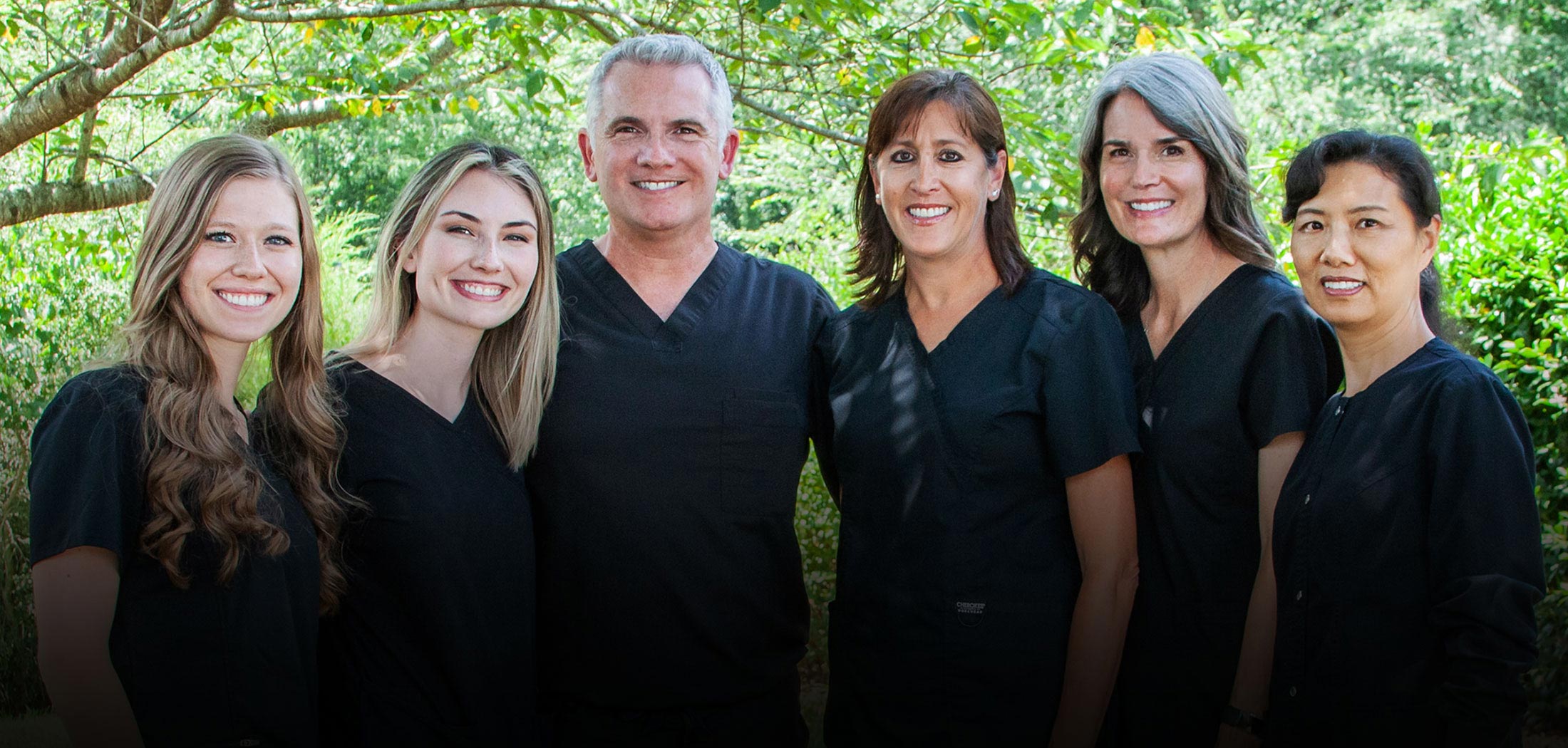 dental team in front of a tree